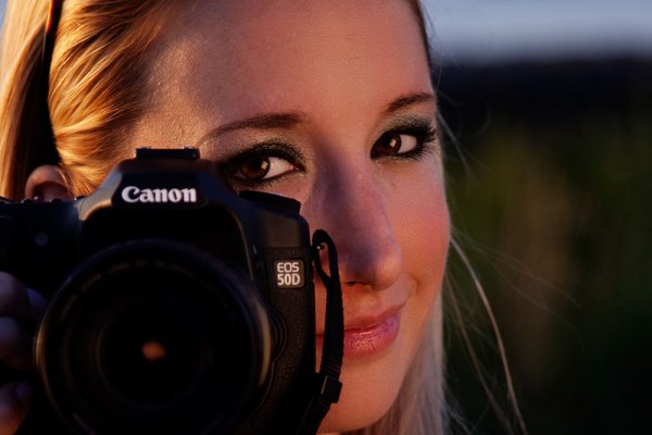 Here's my subject from the shot in front of the bridge. She's a photographer as well now, but back then she was just a hobbyist who wanted to know more about her camera. I used the beautiful sunset light I was getting, and set up a reflector to camera right to bounce the light back into her face.  I wanted her peeking out from behind her camera, illustrating that she's into photography. EOS 5D Mark II with EF 24-105 f/4L IS. 1/250 @ f/4, ISO 100.